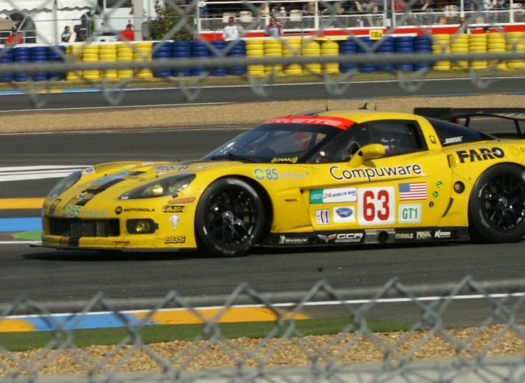 a yellow sports car driving through a track