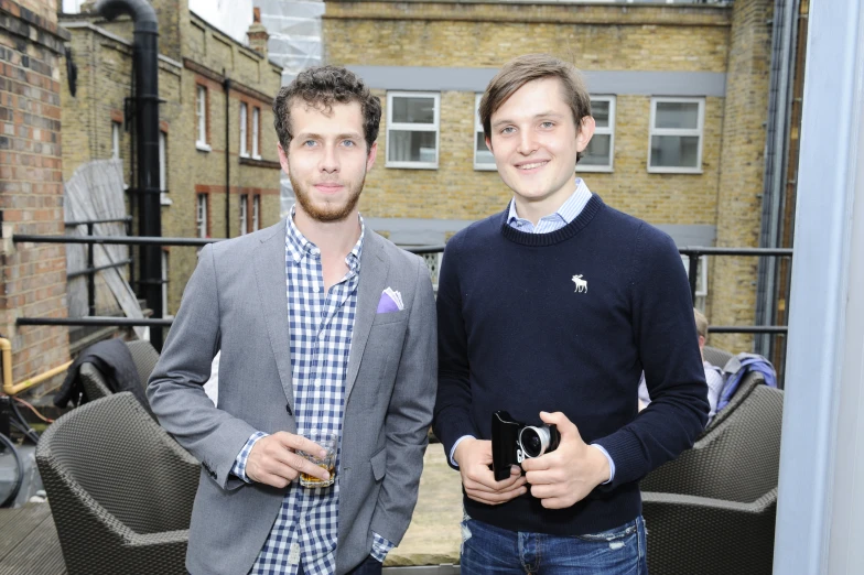 two people standing together on a balcony with buildings