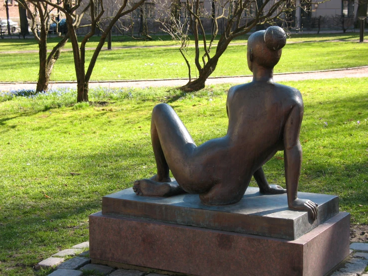 a statue sitting on top of a stone block