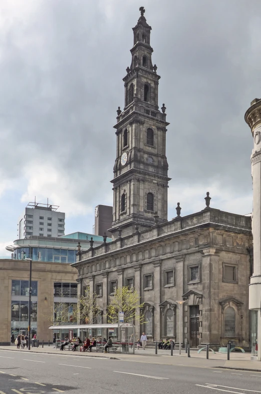 an old church with large steeple stands in the middle of a plaza