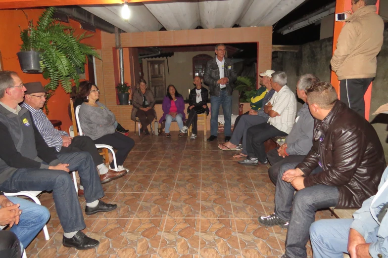 people sitting in chairs around each other in front of an open area