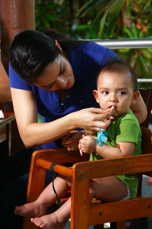 a woman feeding a baby a spoon of food