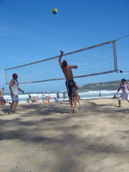 the men are playing volleyball on the beach