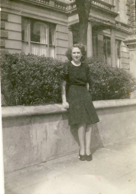 a lady posing in front of an old building