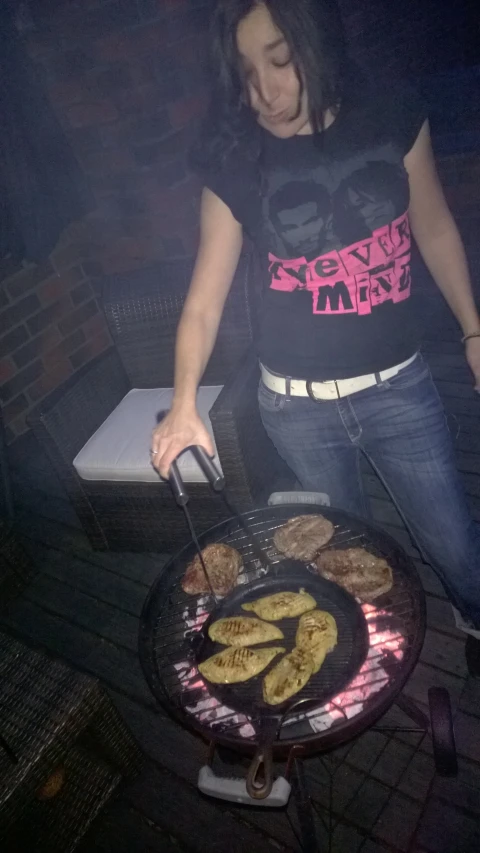 a woman grilling chicken on a round plate