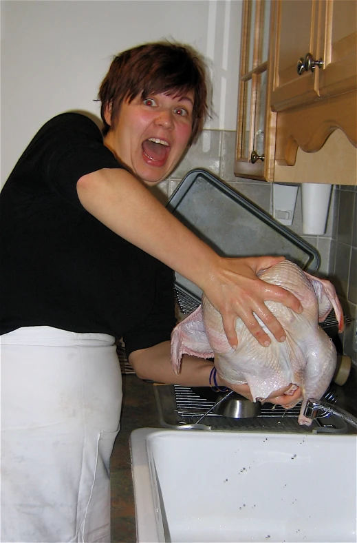 the woman is preparing to cook her turkey