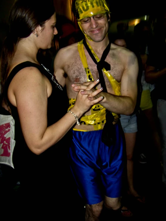 a man in costume standing with a woman wearing a yellow shirt