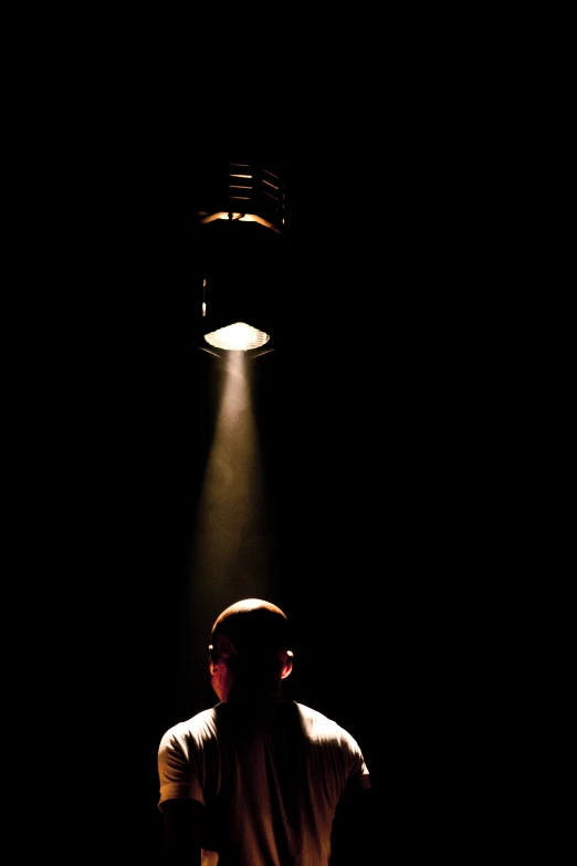 a man in the dark, in the spotlight