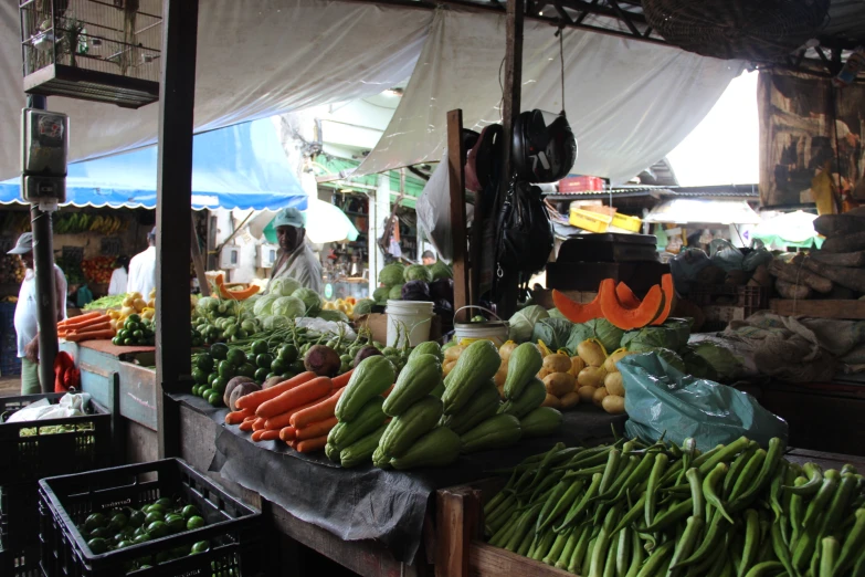 produce and vegetable stand in market area with woman walking by