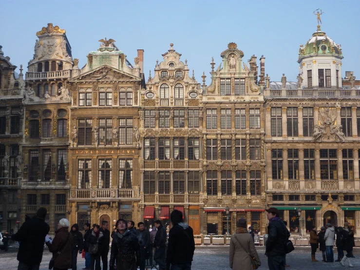 people walking past a large golden building