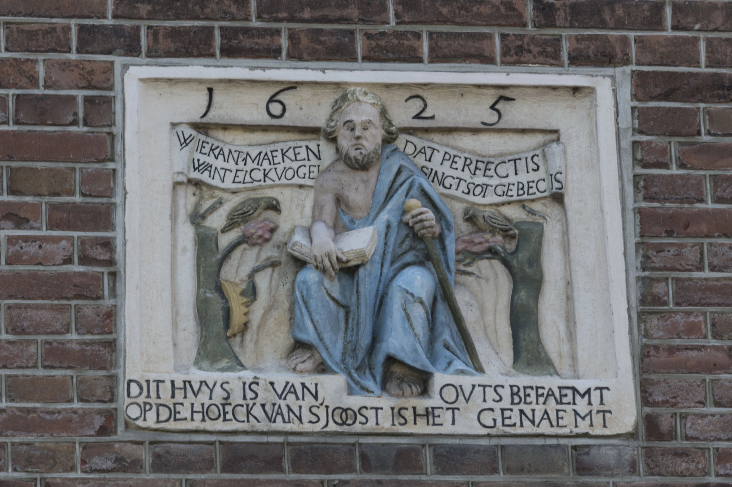 an ornate plaque of st patrick is attached to a brick building