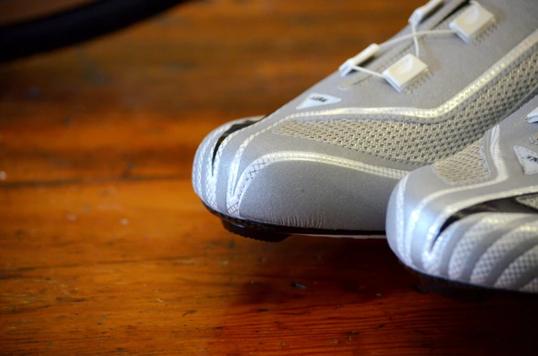 a pair of silver shoes sitting on top of a wooden table