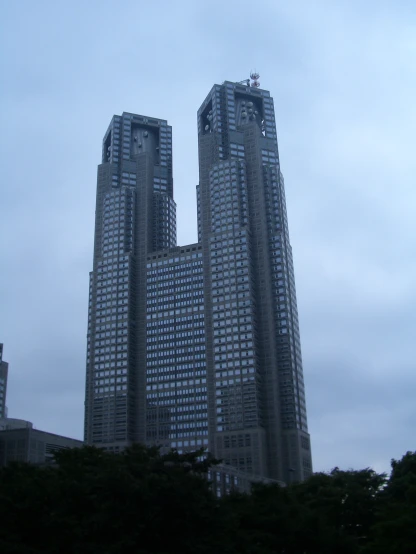 two large tall buildings in a cloudy sky