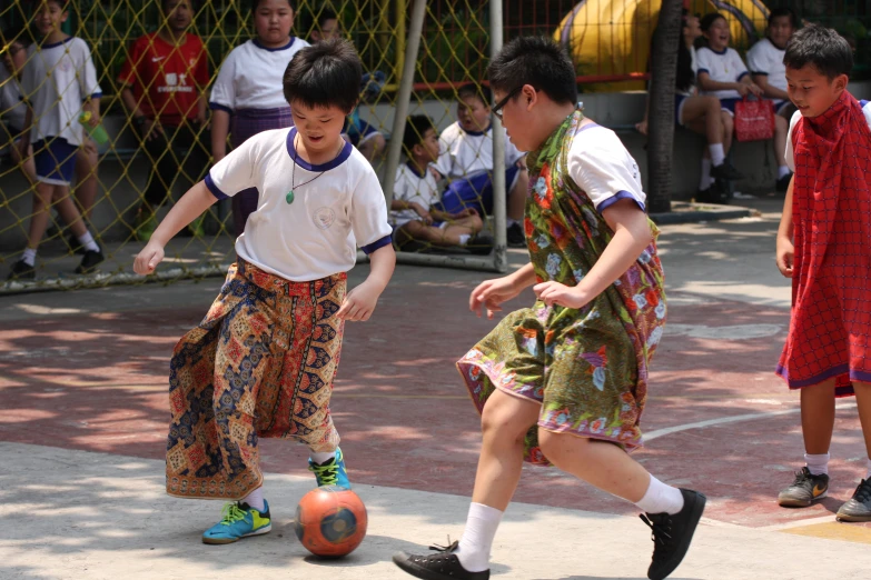 s in school uniforms playing a game of ball