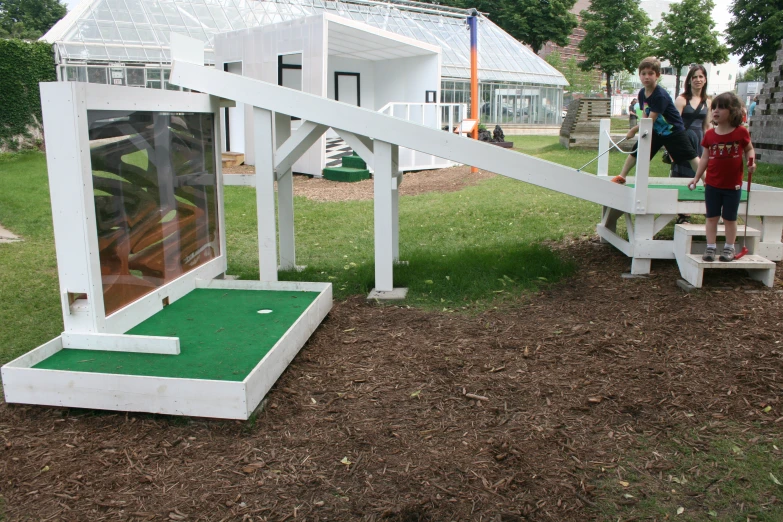 s are playing on the miniature golf course in the backyard