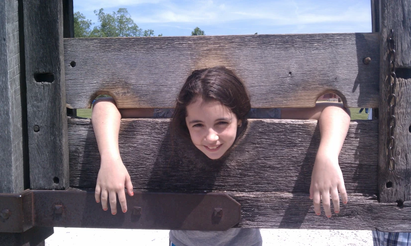a girl with her arms hanging over a bench