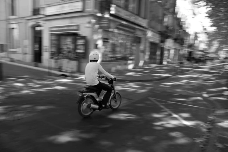 a man riding a motorcycle down the middle of a street