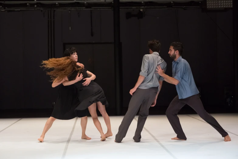 a group of dancers stand together in front of a stage