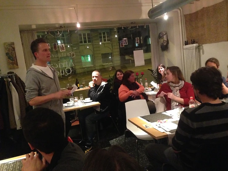 group of people in a room with tables holding wine