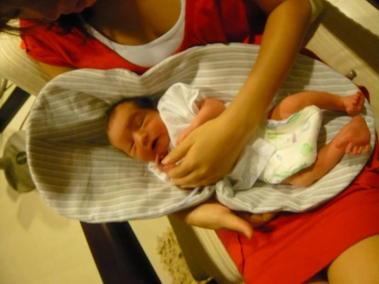 a baby is taking a nap on someone's lap