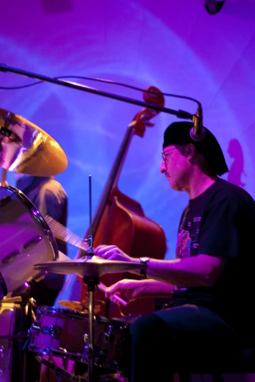 a couple of people are sitting at a drumset