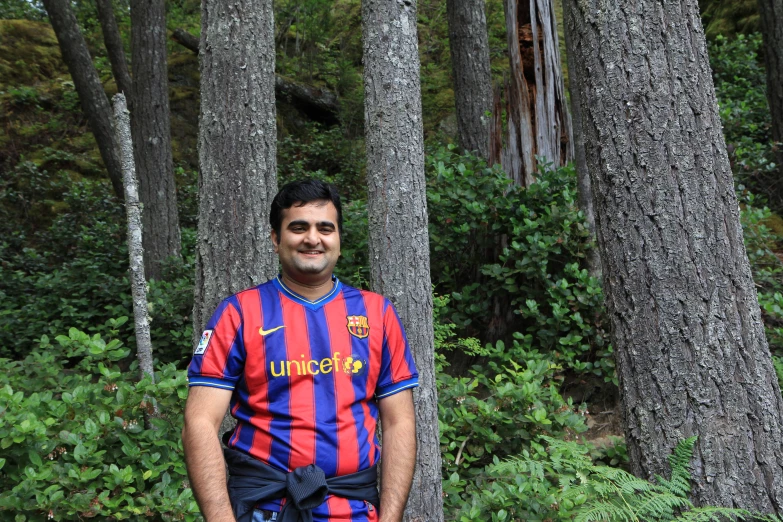 there is a man that is standing in front of some trees