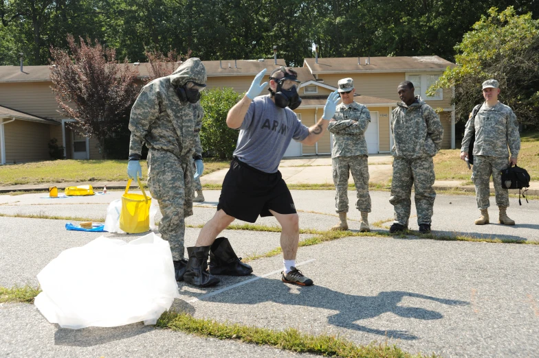 a group of people in camo standing in a driveway near a building