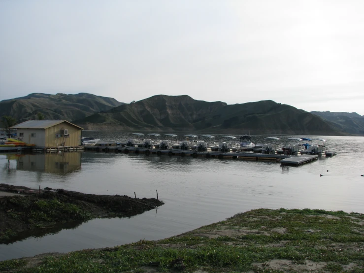 a group of small boats on water near hills