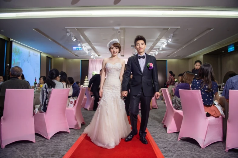 an asian couple pose for wedding pos in a banquet hall