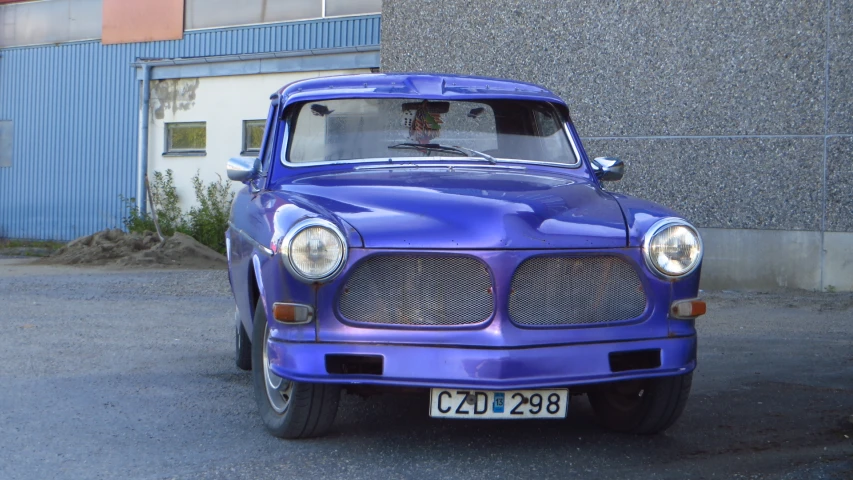 an old classic blue pickup truck with its front grill slightly open