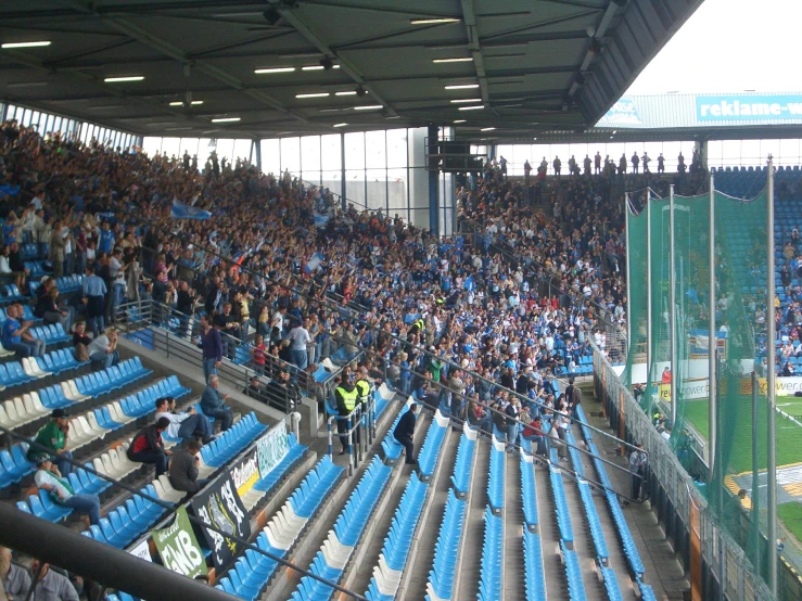 people sitting in bleachers at an indoor soccer match