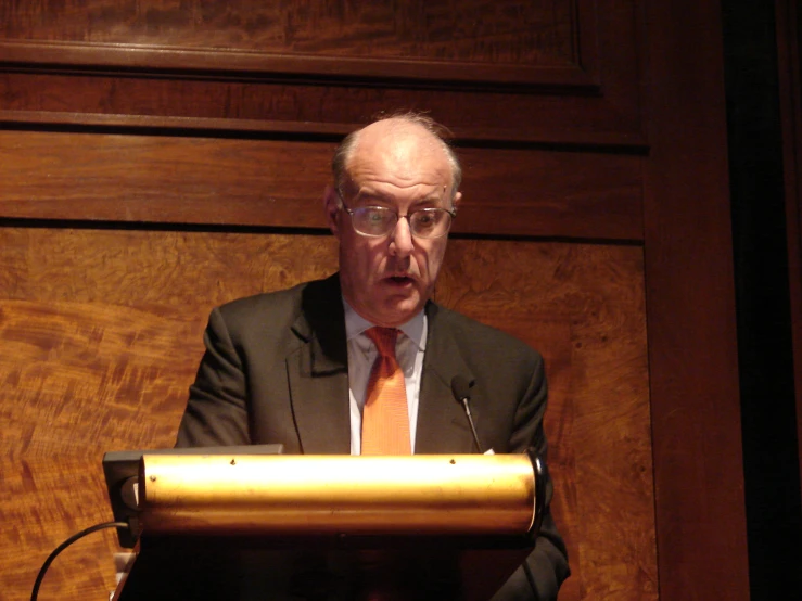 a man stands behind a speaker as he speaks