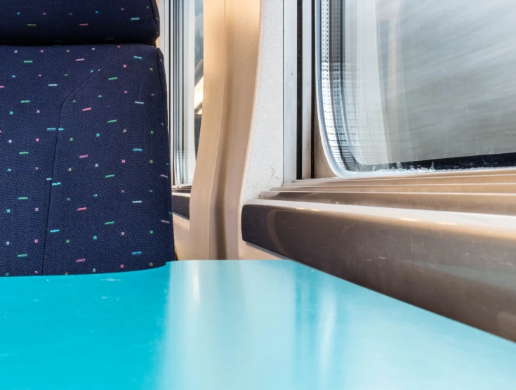 a blue table in a train with windows