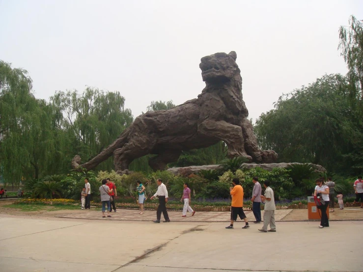 many people are walking in front of the large lion statue