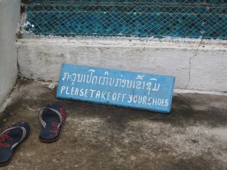 blue sign with writing next to pair of sandals