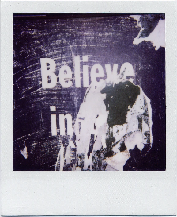 the words believa in white are overlaid with graffiti