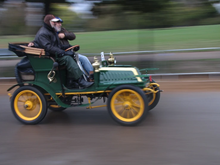 two people sitting in a small green car