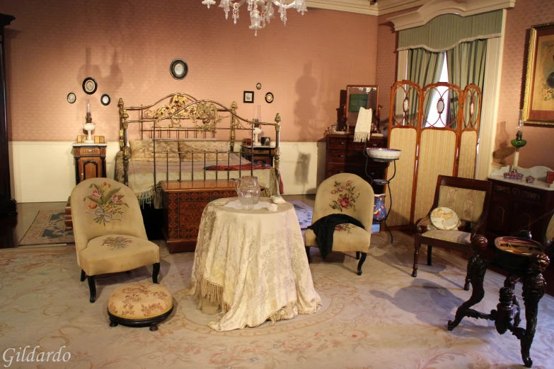 a fancy victorian style bedroom with a bed and chairs