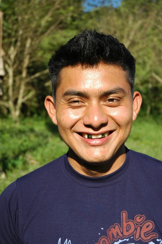 a man posing for the camera in front of trees