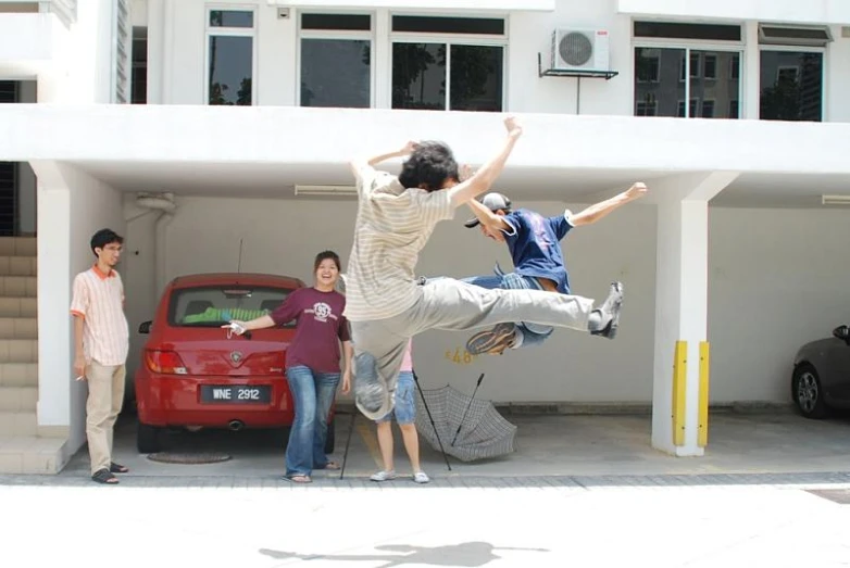 a skateboarder doing tricks by a car and three people