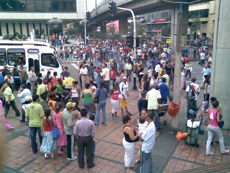 a large group of people are standing on the side walk