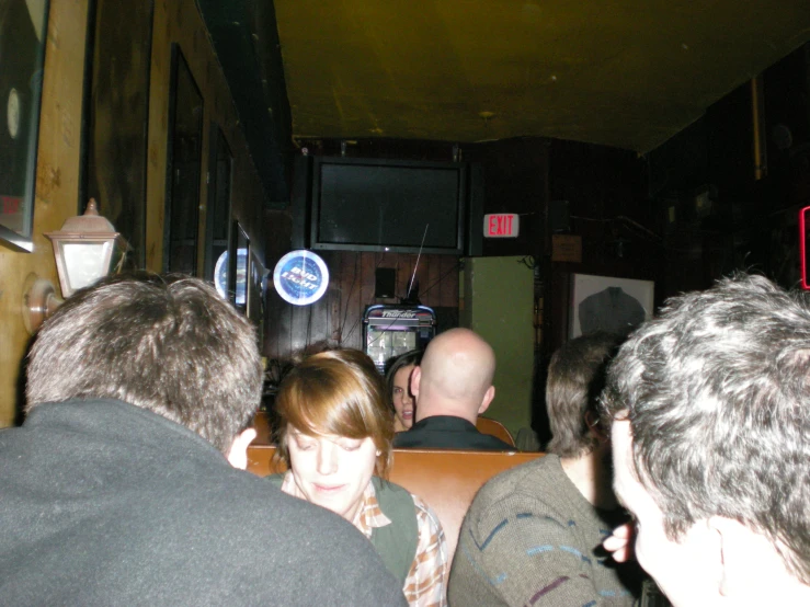 a large group of people waiting at a bar to be served