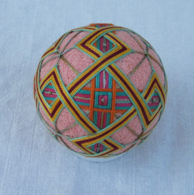 a colorful ball of yarn with patterns on a white background