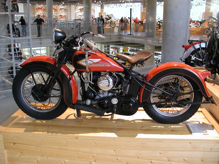 an old motorcycle sitting on a wooden platform