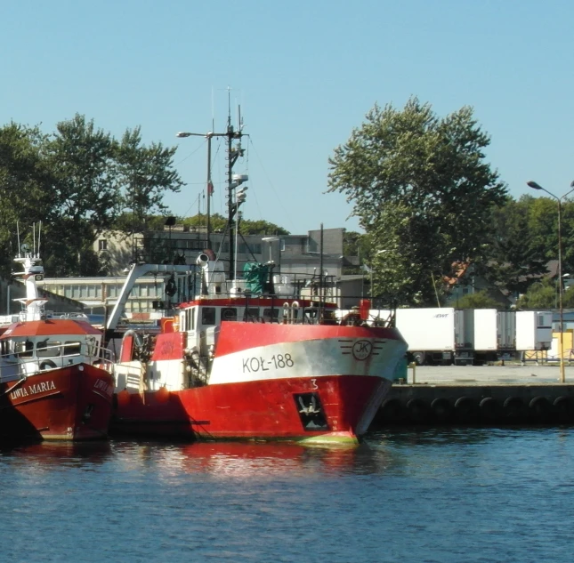 two boats docked at a dock by some trees