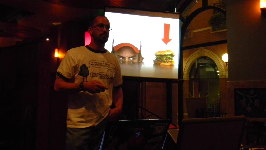 a man at a party standing in front of an animated screen