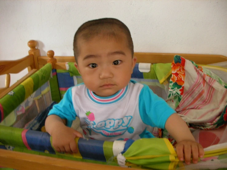 an infant in a baby crib looks to the side