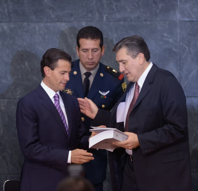 a man is standing up reading a piece of paper