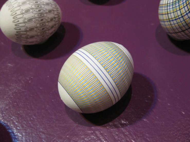 an assortment of decorative easter eggs on purple fabric
