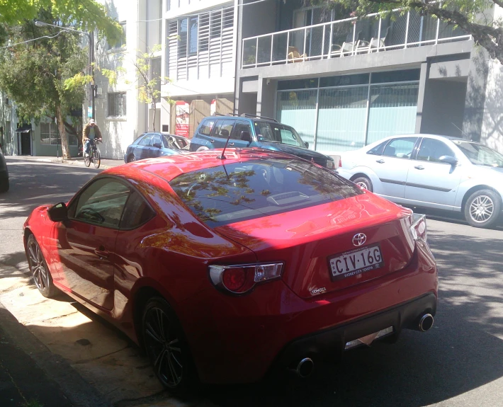 a red sports car is parked in front of some buildings